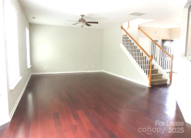 a view of a hallway with wooden floor and staircase