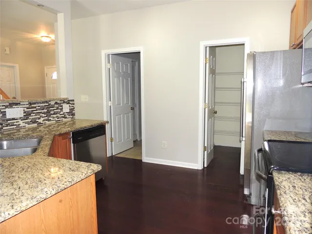 a kitchen with kitchen island granite countertop wooden cabinets and a sink