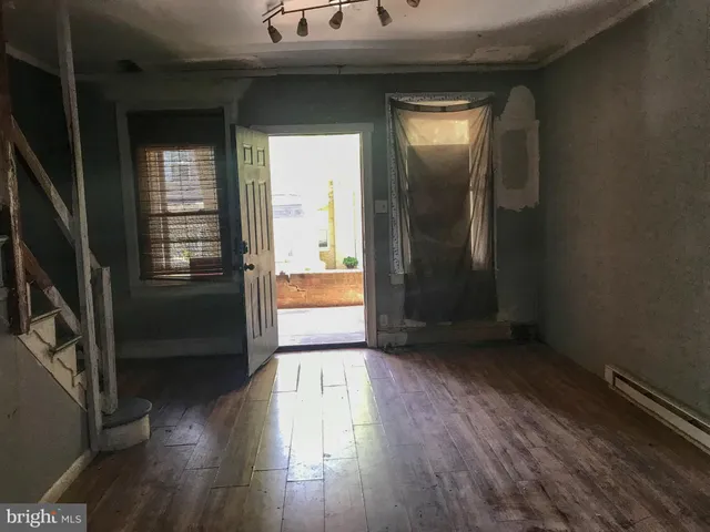 an empty room with wooden floor and a window