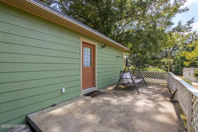 a view of backyard with wooden fence and large trees