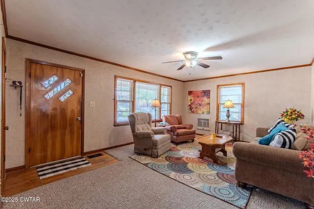a living room with furniture two window and a chandelier