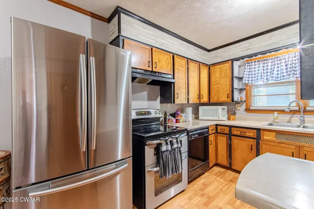 a kitchen with stainless steel appliances granite countertop a refrigerator and a sink