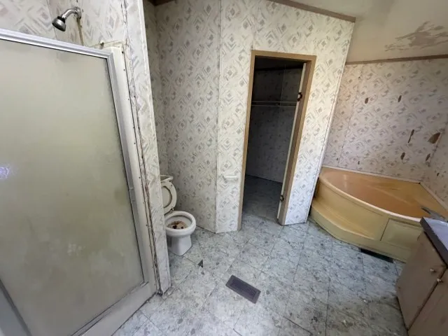 a bathroom with a granite countertop bathtub shower and toilet