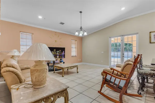 a living room with furniture a fireplace and a chandelier