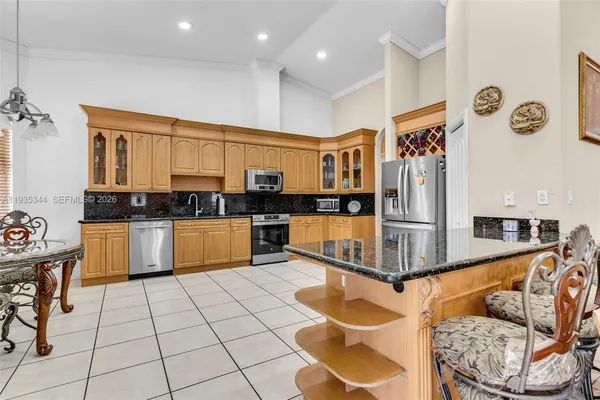 a kitchen with stainless steel appliances kitchen island granite countertop a sink and cabinets