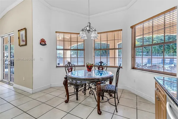 a dining room with furniture a chandelier and window