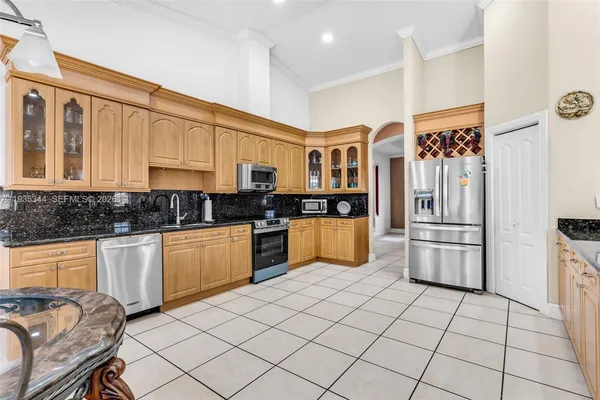 a kitchen with stainless steel appliances granite countertop a refrigerator and a stove top oven