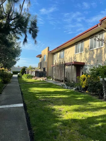 a view of a big house with a big yard and potted plants