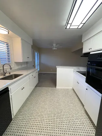 a kitchen with a sink a stove and cabinets