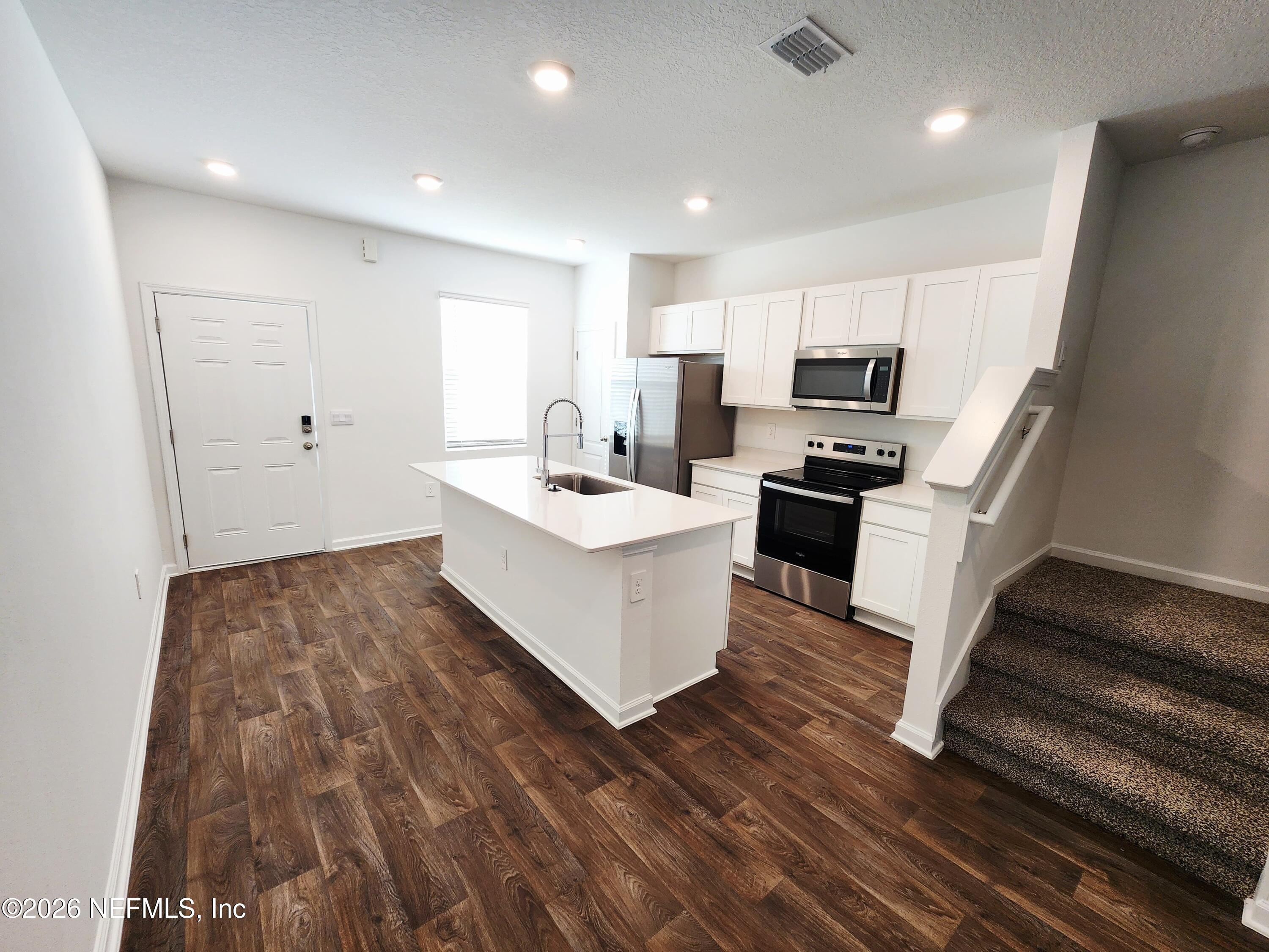 51 Palmetto Rdg Road St. Augustine, FL 32095 - Photo 4 of 16 a large white kitchen with sink stove and refrigerator