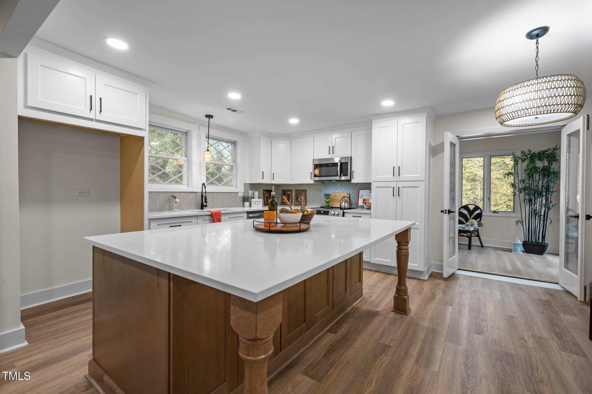 3014 Hope Valley Road Durham, NC 27707 - Photo 10 of 38 a kitchen with kitchen island granite countertop a sink a counter top space stainless steel appliances and cabinets