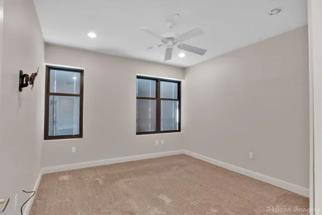 an empty room with a ceiling fan and bathroom