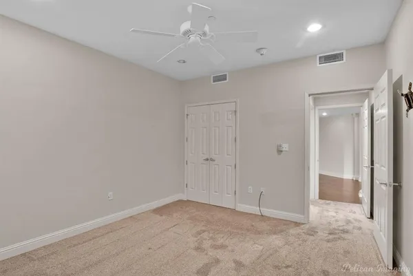 an empty room with closet and ceiling fan
