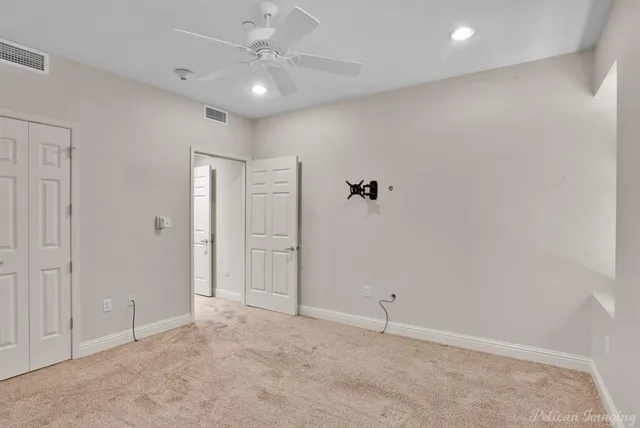 an empty room with wooden floor and closet area