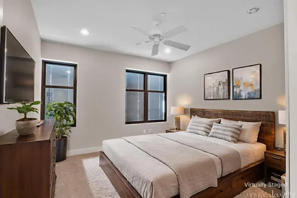 a bedroom with a large bed and a chandelier