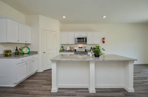 a kitchen with kitchen island white cabinets and appliances