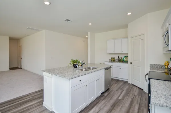 a kitchen with granite countertop white cabinets and white appliances