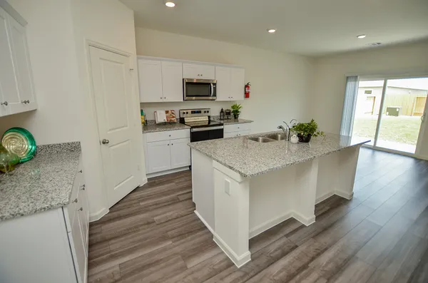 a kitchen with a sink and wooden floor