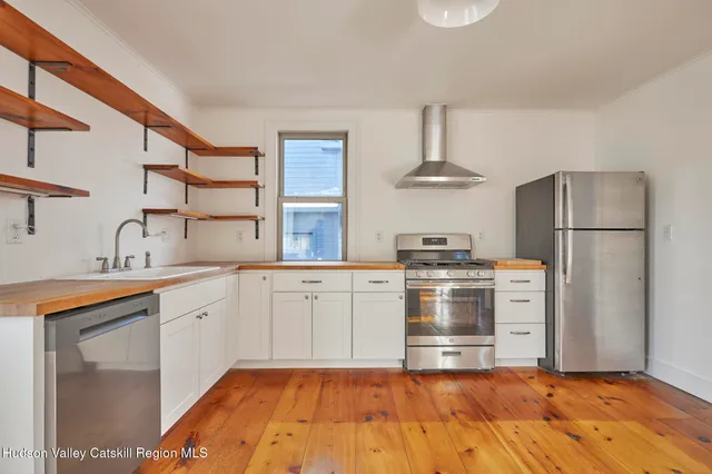 a kitchen with a stove top oven and refrigerator