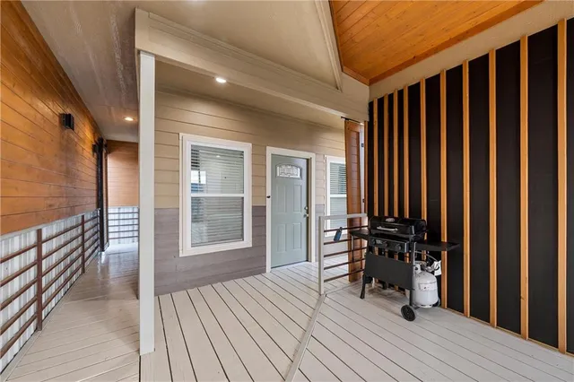 a view of a balcony with chairs and wooden floor