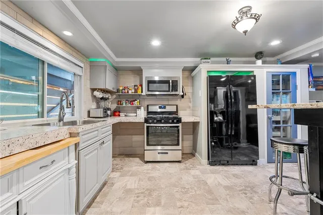 a kitchen with stainless steel appliances granite countertop a refrigerator and a stove top oven