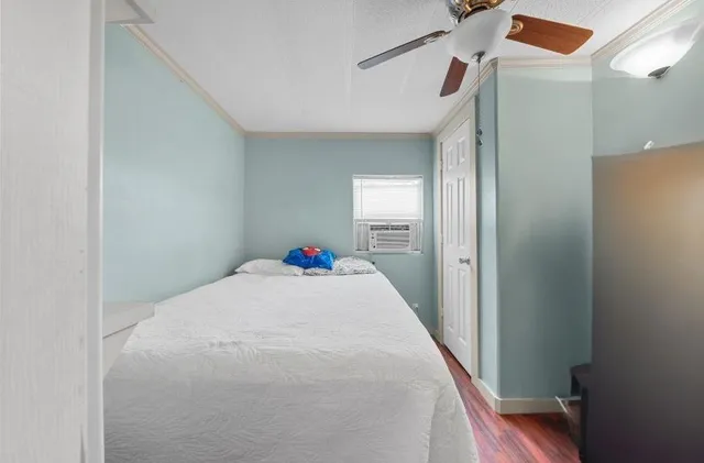 a bedroom with wooden floor and closet