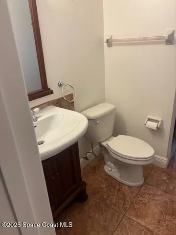a white toilet sitting next to a bathroom sink