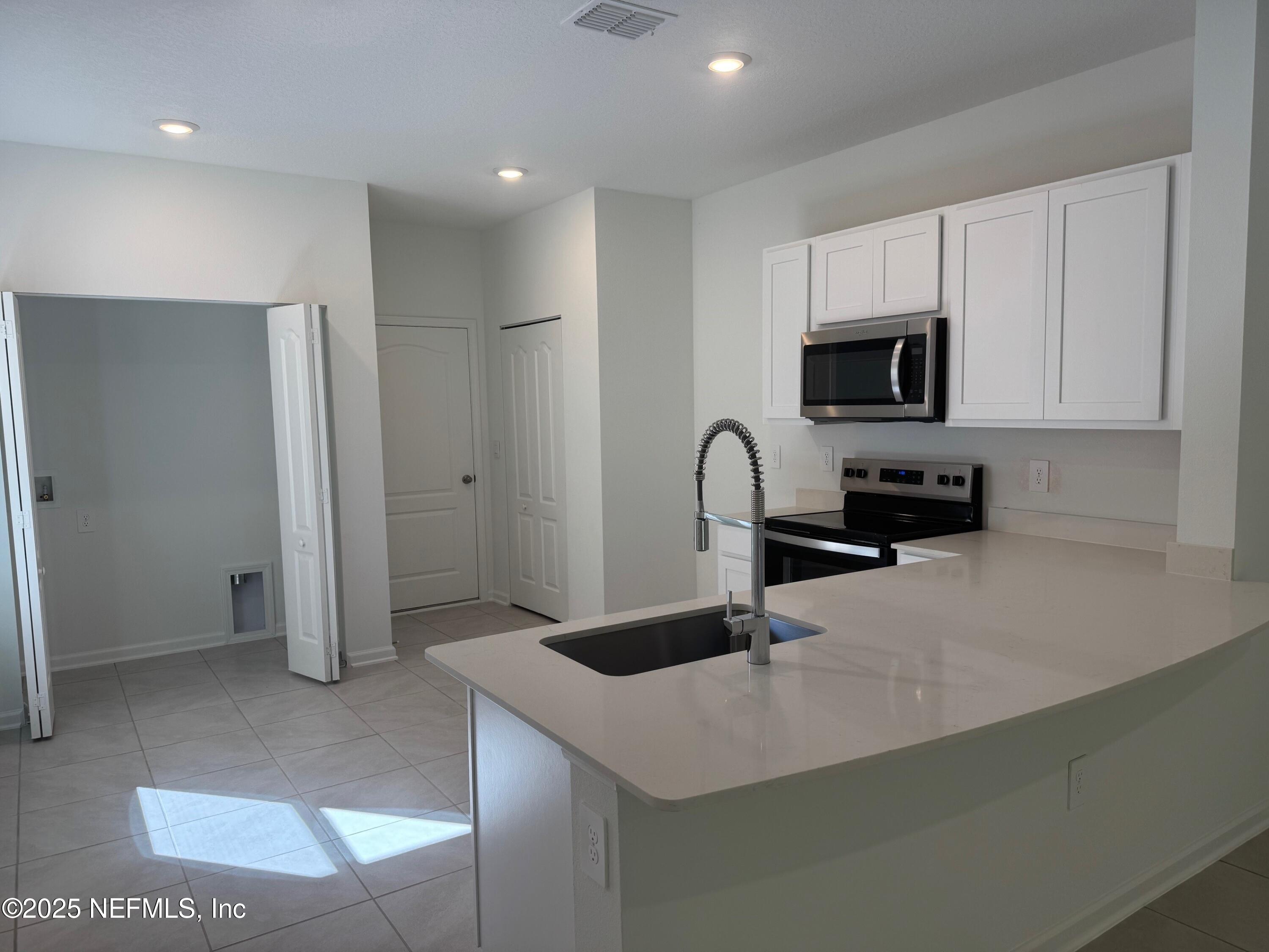 65 Blue Hvn Road St. Augustine, FL 32095 - Photo 5 of 57 a kitchen with stainless steel appliances a sink a refrigerator and a stove