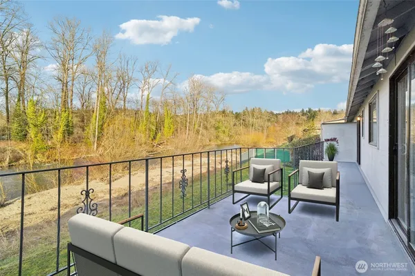 a balcony with chairs and a potted plant