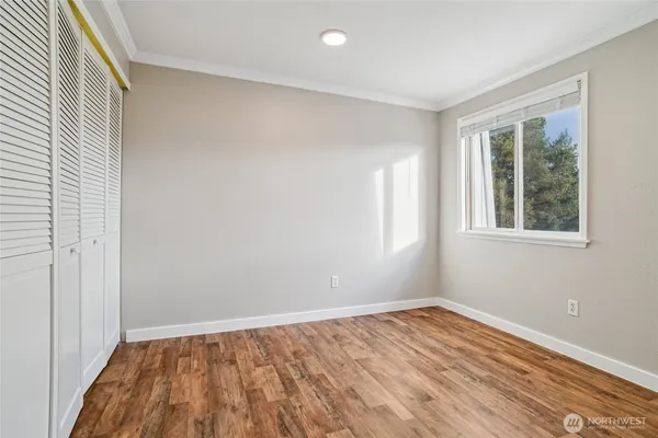 a view of empty room with wooden floor and entryway