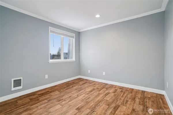 a view of an empty room with wooden floor