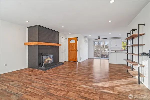a view of empty room with wooden floor and fireplace