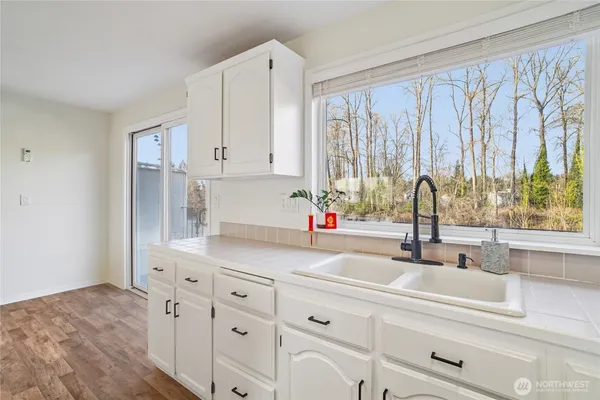 a kitchen with stainless steel appliances white cabinets and a window