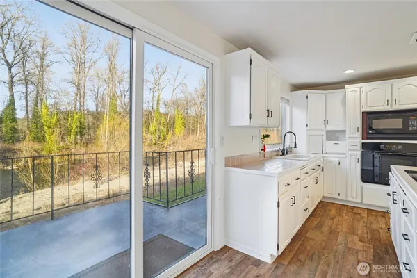 a kitchen with white cabinets and black stainless steel appliances