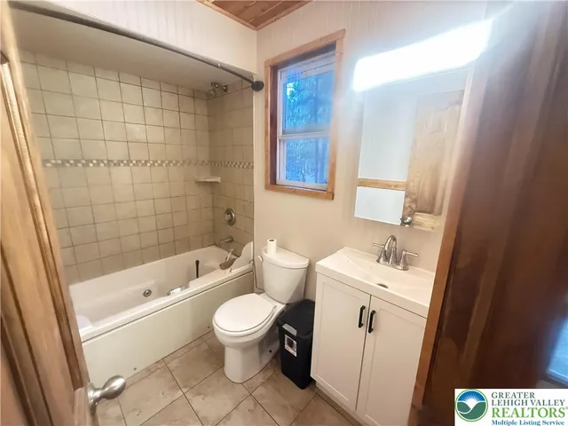 a bathroom with a toilet a sink a mirror a bathtub and shower