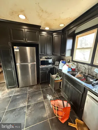 a kitchen with granite countertop a sink cabinets and stainless steel appliances