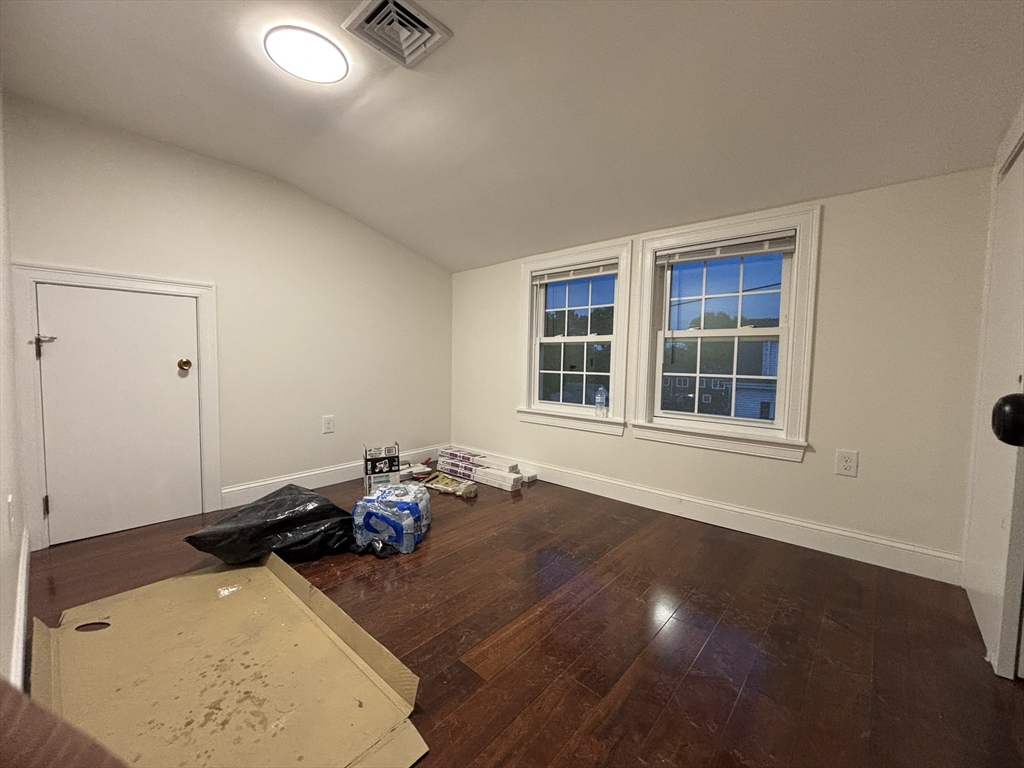 4 Appleton Street, Unit D Quincy, MA 02171 - Photo 11 of 12 an empty room with wooden floor and windows