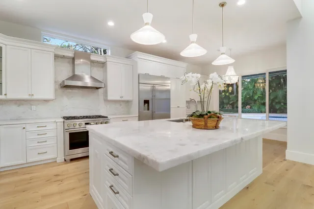 a kitchen with white cabinets and stainless steel appliances