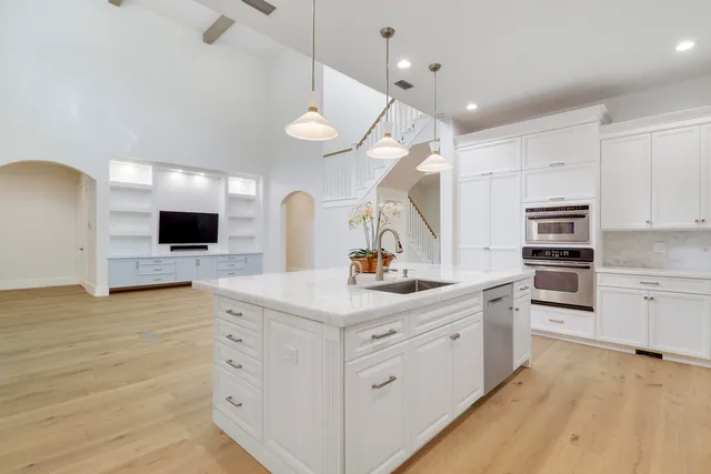 a large kitchen with kitchen island a sink stainless steel appliances and cabinets