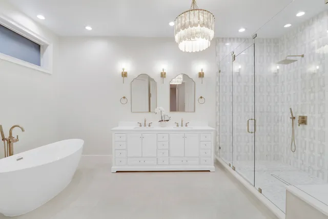 a spacious bathroom with double sink a mirror a shower and a bathtub