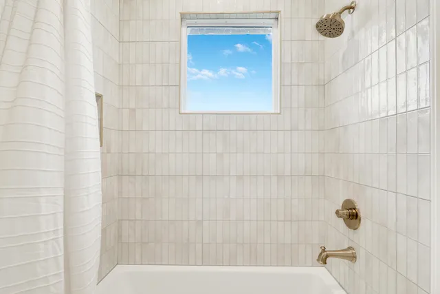 a bathroom with a shower and a sink a mirror