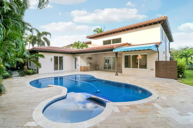 a front view of a house with a yard and potted plants