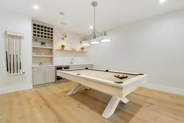 a room with pool table and windows