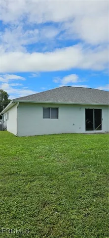 a view of a backyard with plants and large trees