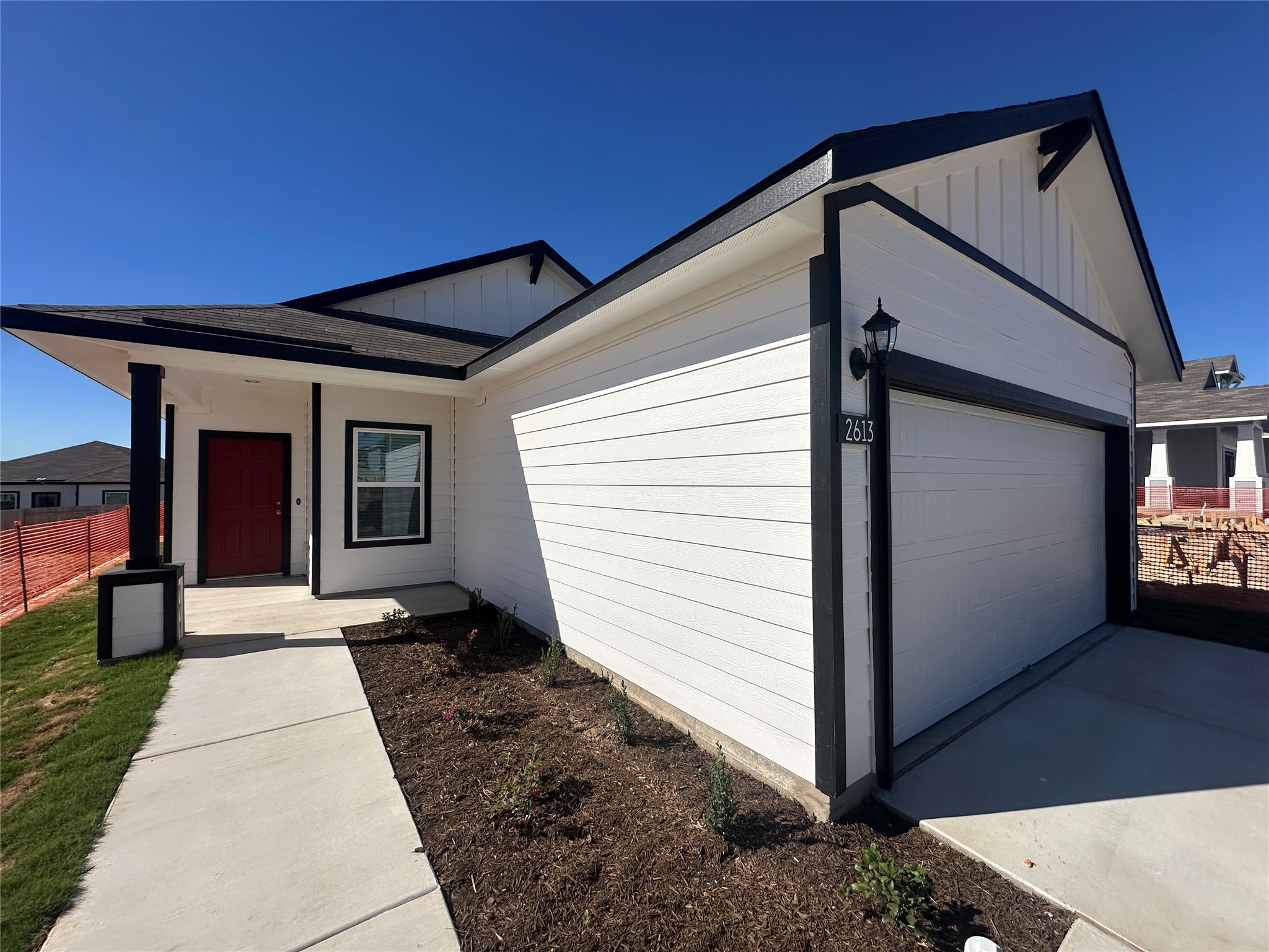 View of front facade featuring an attached garage, board and batten siding, and a porch