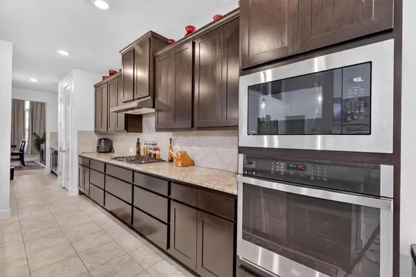 a kitchen with stainless steel appliances granite countertop a stove a sink and a refrigerator