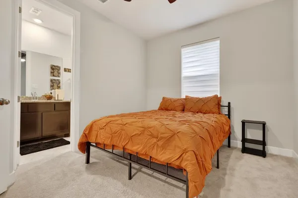 a bed sitting in a bedroom next to a window and dresser