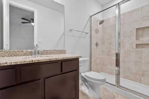 a bathroom with a granite countertop sink toilet and shower