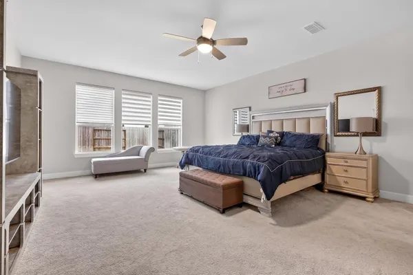a spacious bedroom with a bed and a large window with the outer view