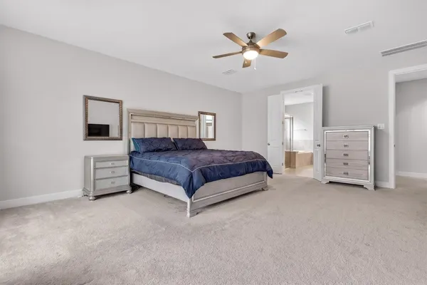 a spacious bedroom with a bed and a chandelier